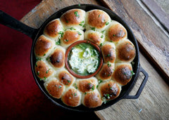 Dough balls baked in an cast iron skillet and brushed with garlic butter made using a dough balls recipe