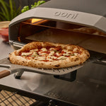 ooni signature perforated pizza peel retrieving pizza from oven