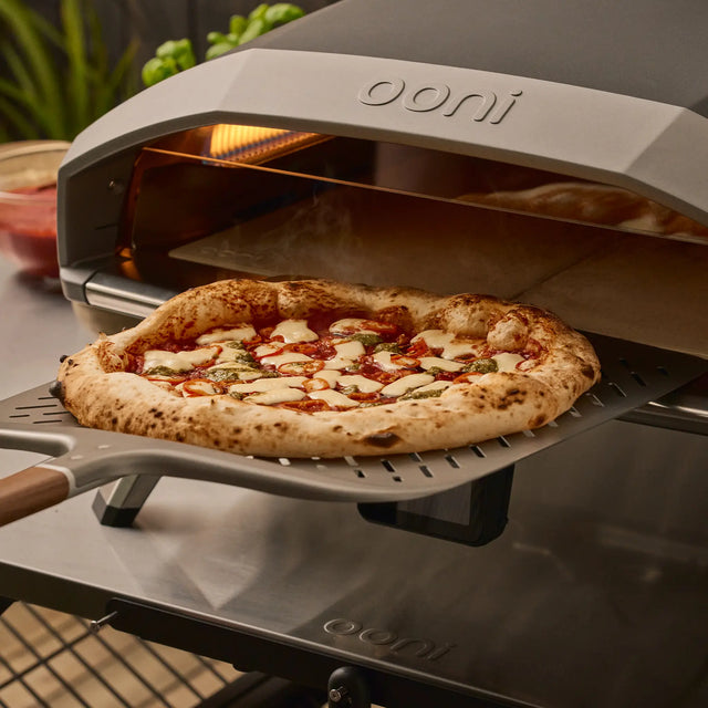 ooni signature perforated pizza peel retrieving pizza from oven