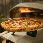 wide turning peel retrieving pizza from oven 