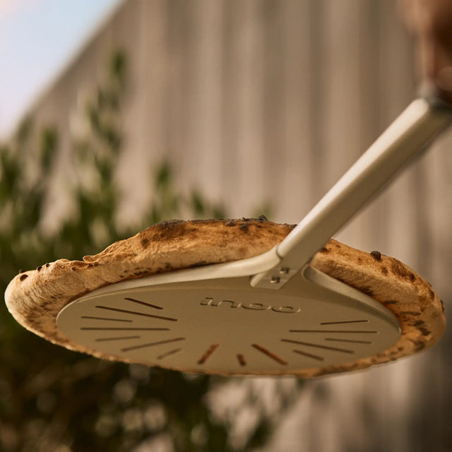 wide turning peel lifting pizza, view from below pizza 