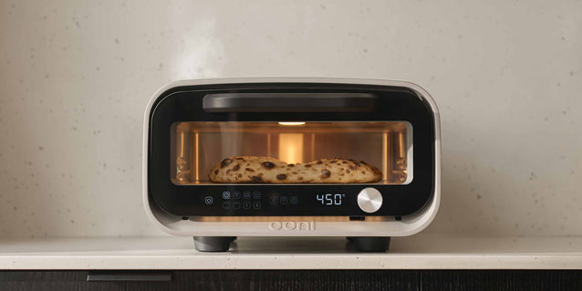Volt 2 electric pizza oven with pizza cooking inside. 