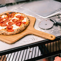 Pizza served on top of Bamboo Peel with Pizza Cutter at the side