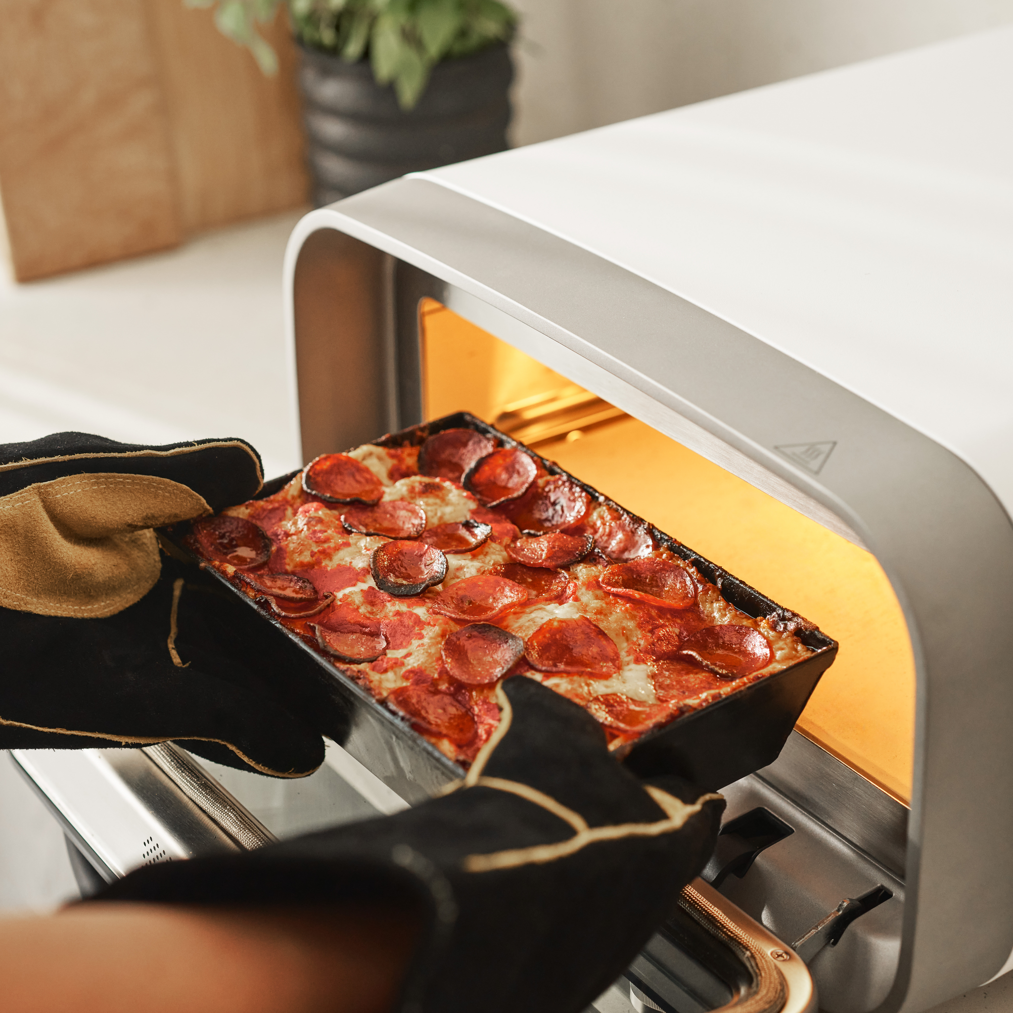 Detroit pan being retrieved from votl 2 electric pizza oven 